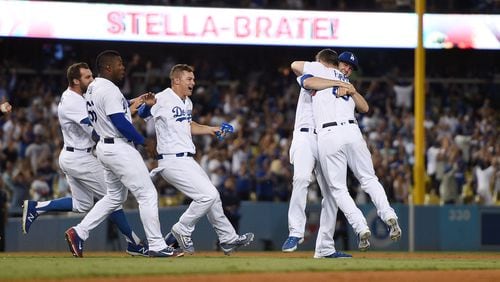 Kyle Farmer of the Los Angeles Dodgers is congratulated by teammates after hitting a game-winning double in his first MLB at-bat against the San Francisco Giants in the 11th inning at Dodger Stadium on July 30, 2017, in Los Angeles, California. (Photo by Kevork Djansezian/Getty Images)