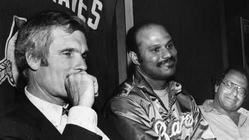 Braves first baseman Chris Chambliss (middle) sits next to team owner Ted Turner (left) at a press conference. AJC file photo