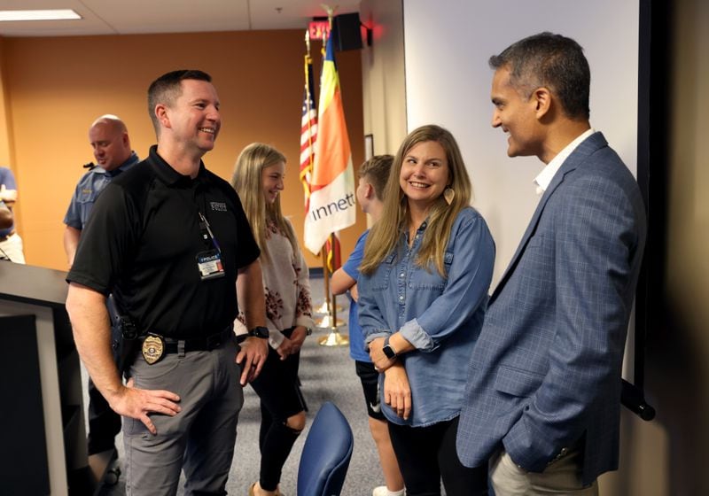 Gwinnett County Police officer Doug Loomis, left, and his wife Ashley, center, talks with Dr. Salil Patel as Loomis thanks first responders that helped him after going into cardiac arrest at the Gwinnett County Justice and Administration Center, Wednesday, September 21, 2022, in Lawrenceville. (Jason Getz / Jason.Getz@ajc.com)