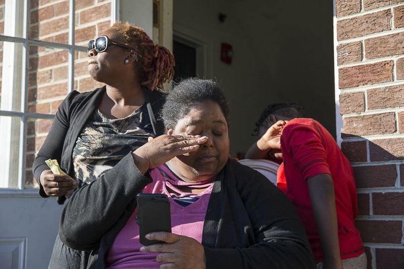 La-Raesha Steward (left) comforts Sonja D. Harrison as she tears up while looking at photos of her daughter Sonja Star Harrison, 14, at Pavilion Place apartments November 2018. The teen was babysitting when a bullet came through the ceiling of the room where she sat and struck her in the head, killing her. (Alyssa Pointer / AJC 2018)