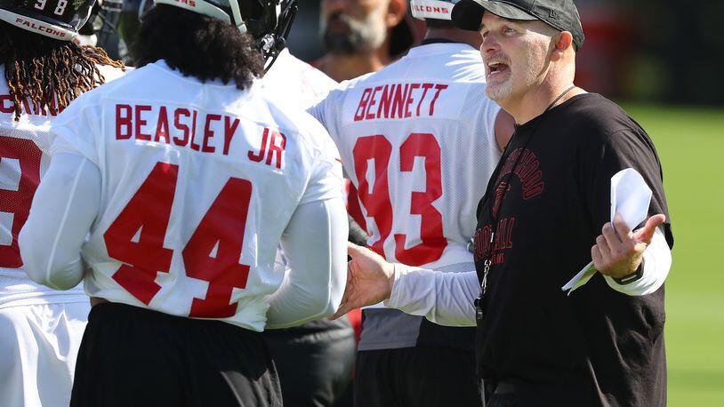 July 22, 2019 Flowery Branch: Falcons head coach Dan Quinn works with Vic Beasley Jr. on his defense after a play during the first practice at training camp on Monday, July 22, 2019, in Flowery Branch.   Curtis Compton/ccompton@ajc.com