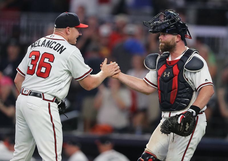 Braves pitcher Mark Melancon gets five from catcher Brian McCann as they close out the New York Mets during the ninth inning for a 5-3 victory.   Curtis Compton/ccompton@ajc.com