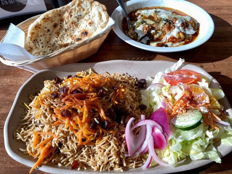 Olomi’s Grill in Johns Creek serves an impeccable version of the crown jewel of Afghani cuisine: Kabuli pulao (lamb pilaf), shown here with Iranian-style barbari flatbread and borani bandjan (eggplant and potatoes). 
Wendell Brock for The Atlanta Journal-Constitution