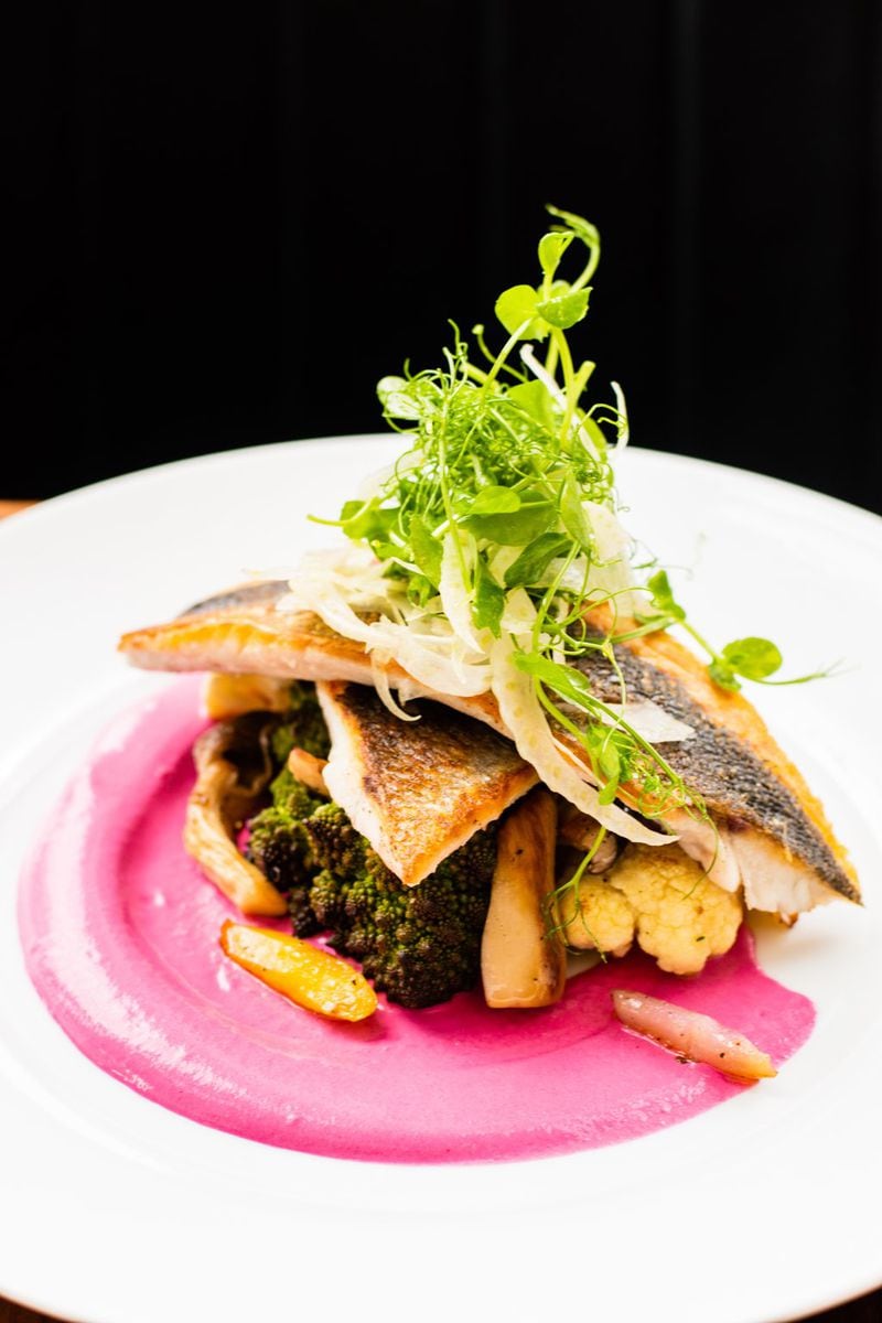 Seared black sea bass at Mission and Market is served with roasted vegetables atop a bright pink swath of beet raita. CONTRIBUTED BY HENRI HOLLIS
