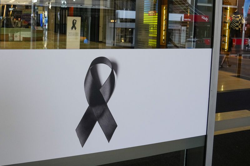 Black ribbons are displayed on the doors to the Westfield mall at Bondi Junction in Sydney, Thursday, April 18, 2024. The Sydney shopping mall has been opened to the public for the first time since it became the scene of a mass stabbing in which six people died, while the Australian prime minister has flagged giving citizenship to an immigrant security guard who was injured while confronting the knife-wielding attacker. (AP Photo/Mark Baker)