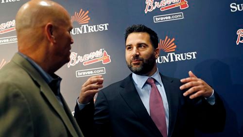 Braves manager Brian Snitker (left) is among the many team employees who say they’ve been impressed and re-energized after getting to know new Braves general manager Alex Anthopoulos, who is pictured here chatting with Snitker on the day Anthopoulos’ hiring was announced in November. (AP file photo/David Goldman)