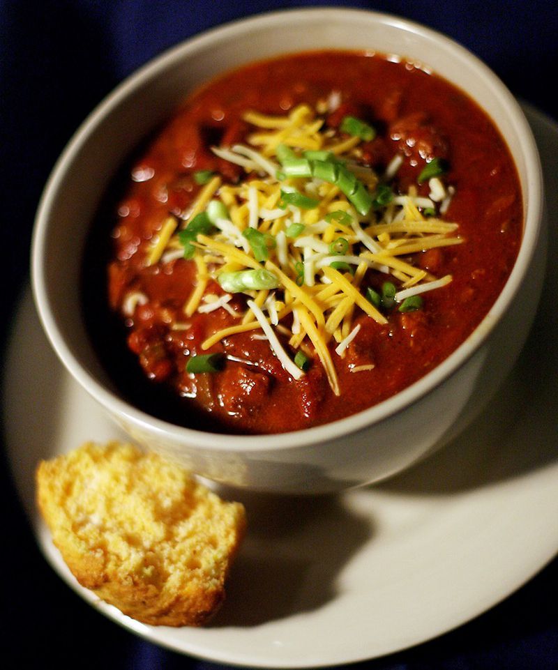 Chili garnished with cheese and scallions and served with a side of cornbread is perfect for a cold winter night. (Amy Leang/Detroit Free Press/TNS)