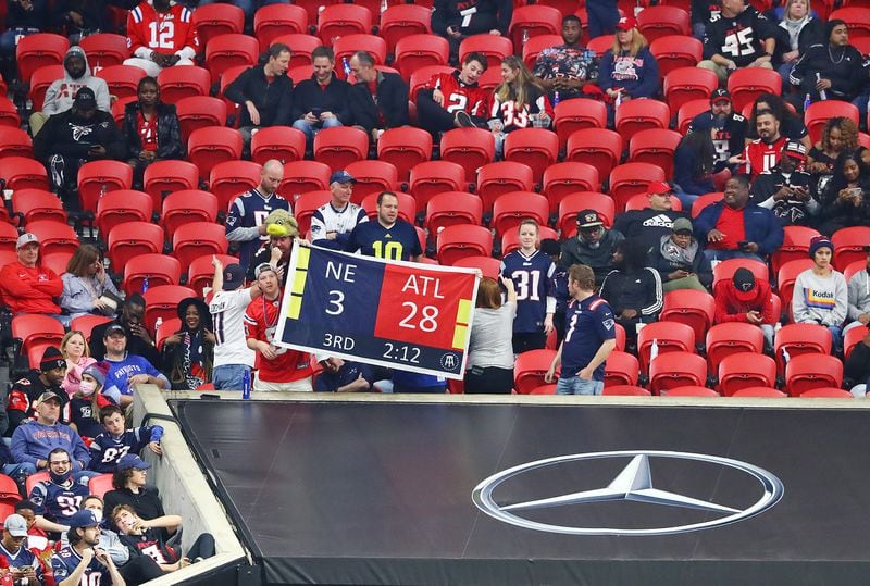 During the Falcons' 25-0 loss to New England on Nov. 18, 2021, Mercedes-Benz Stadium sports many empty seats as Patriots fans hold a sign reminding Falcons fans of their team's blown Super Bowl lead. (Photo by Curtis Compton / Curtis.Compton@ajc.com)