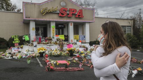 An emotional Hollis Wright gazes at the memorial-strewn front of the Gold Spa on Piedmont Avenue on Wednesday, March 24, 2021 in Atlanta. Wright regularly drives by the spa while taking her daughter to daycare. On this day she stopped to look at the flowers and read the notes left behind. The Gold Spa and the Aromatherapy Spa in Atlanta are two of the three spas where eight people were killed by a gunman on March 16, 2021. Six of the eight victims were Asian women. (John Spink / John.Spink@ajc.com)