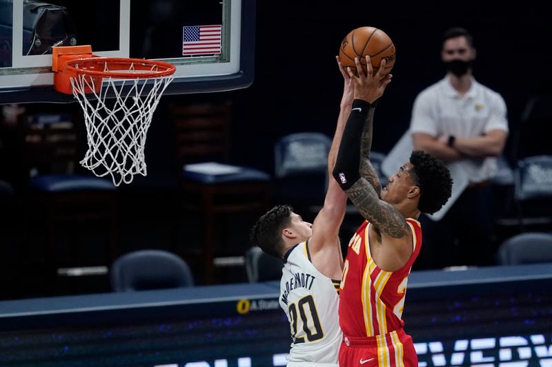 Atlanta Hawks' John Collins, right, is fouled by Indiana Pacers' Doug McDermott during the second half of an NBA basketball game Thursday, May 6, 2021, in Indianapolis. (AP Photo/Darron Cummings)