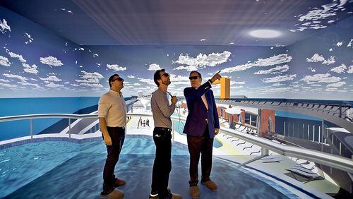 Wearing 3D glasses, Richard Fain, chairman and CEO of Royal Caribbean Cruises Limited (right) chats with architects Paul Moreira (left) and Tom Wright inside the 3D cave which is part of the new ship technology Royal Caribbean unveiled in Miami. Patrick Farrell/Miami Herald/TNS