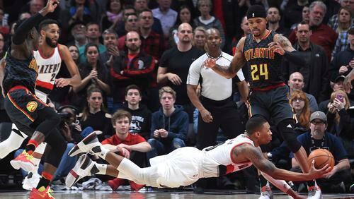 Portland Trail Blazers guard Damian Lillard falls to the court as he drives to the basket during overtime of an NBA basketball game against the Atlanta Hawksin Portland, Ore., Monday, Feb 13, 2017. Atlanta won in overtime 109-104. (AP Photo/Steve Dykes)