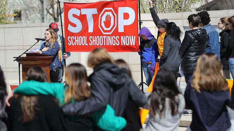 Students look on while Druid Hills High School junior Anabette Vellines speaks out against gun violence during a rally in Liberty Plaza at the Georgia Capitol after their school walkouts Wednesday. At the conclusion of the rally, many attempted to meet with their state representatives.  Curtis Compton/ccompton@ajc.com