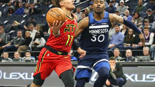 Hawks' Trae Young, left, drives past Minnesota Timberwolves' Kelan Martin in the second half of an NBA basketball game Wednesday, Feb. 5, 2020, in Minneapolis. The Hawks won 127-120. Young led the Hawks with 38 points. AP Photo/Jim Mone)