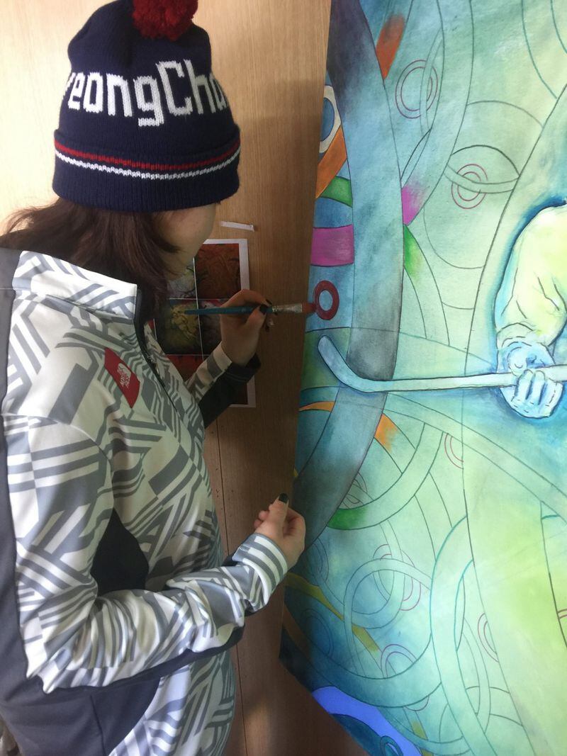 Kim Knowles, a member of the South Korean women’s hockey team, adds her mark to the collaborative paintings organized by Olympian and artist Roald Bradstock. CONTRIBUTED BY ROALD BRADSTOCK