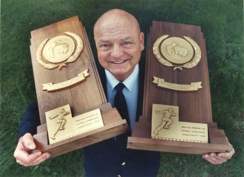 Erk Russell is shown with two of three Division I-AA championship trophies that he won during eight seasons at Georgia Southern. Russell led the Eagles to the national championships in 1985, 86 and 89. As head coach, he went 83-22-1.