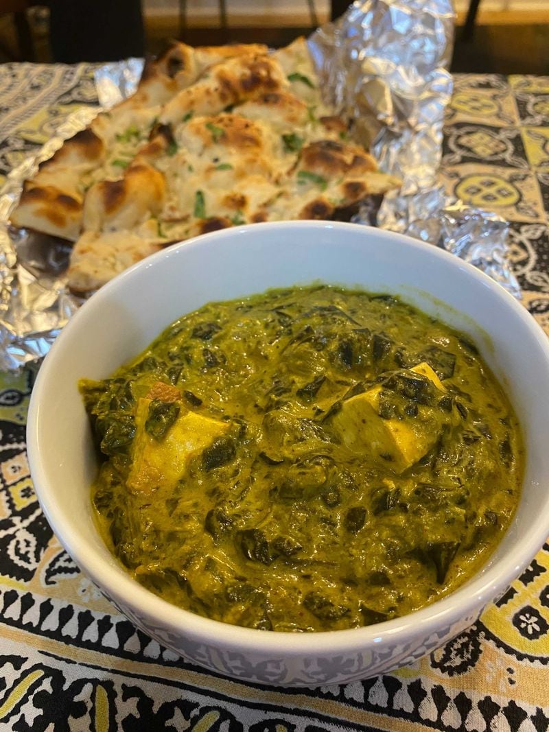 Saag paneer (foreground) and garlic naan are among the offerings at Royal Spice. Ligaya Figueras/ligaya.figueras@ajc.com
