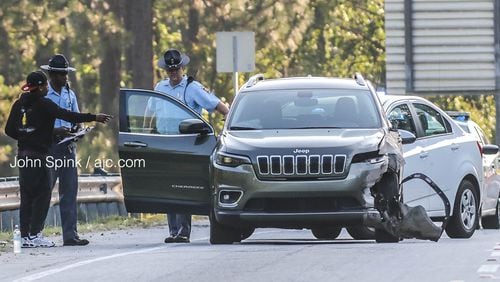 State troopers speak with a driver on the scene of a pedestrian crash on the I-85 South ramp to Jonesboro Road on Friday morning.