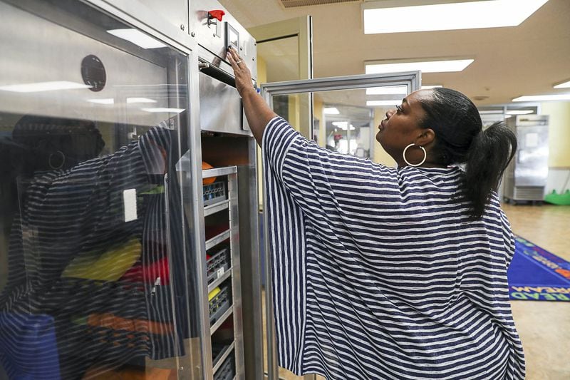 In this December photo, TaJuana Ray, curriculum coordinator of pre-K at Kids R Kids, operates a ZONO Sanitizing cabinet at the Learning Academy day care center in Marietta. ALYSSA POINTER / ALYSSA.POINTER@AJC.COM