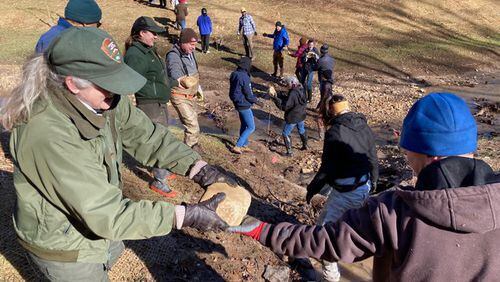 Volunteers gathered in February at Crayfish Creek in Sugar Hill to extend stabilization efforts into the creek with stones, boulders and huge logs that will also serve as habitat for aquatic wildlife. (Courtesy Tixie Fowler, Gwinnett County Soil and Water Conservation District)