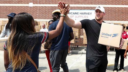 Anna Ucheomumu high-fives Texans defensive end J.J. Watt after loading a car with relief supplies for people impacted by Hurricane Harvey on Sunday in Houston. Watt's Hurricane Harvey Relief Fund has raised more than $20 million to date to help those affected by the storm.