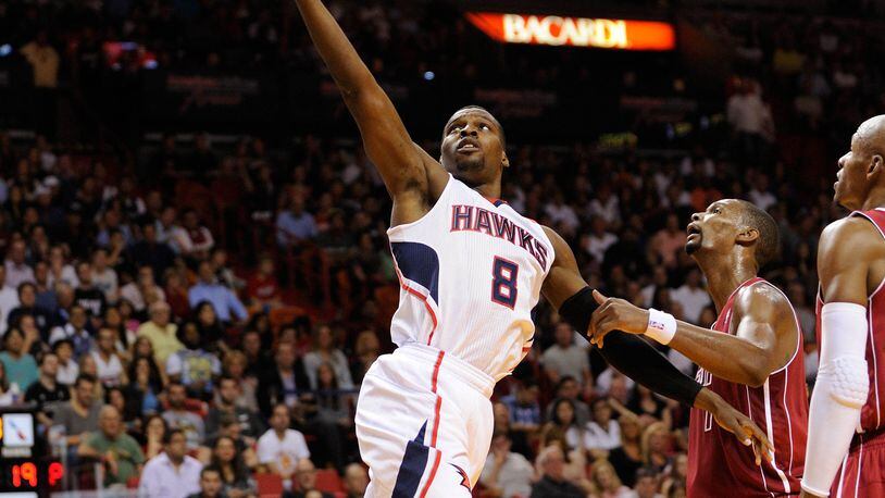 Dec 23, 2013; Miami, FL, USA; Atlanta Hawks point guard Shelvin Mack (8) drives to the basket as Miami Heat center Chris Bosh (1) looks on during the first half at American Airlines Arena. Mandatory Credit: Steve Mitchell-USA TODAY Sports