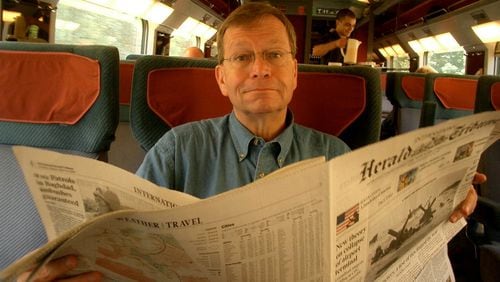 Dick Williams in 2004 in London with a newspaper, a medium he always loved. Williams was a fixture in Atlanta journalism for decades. CONTRIBUTED