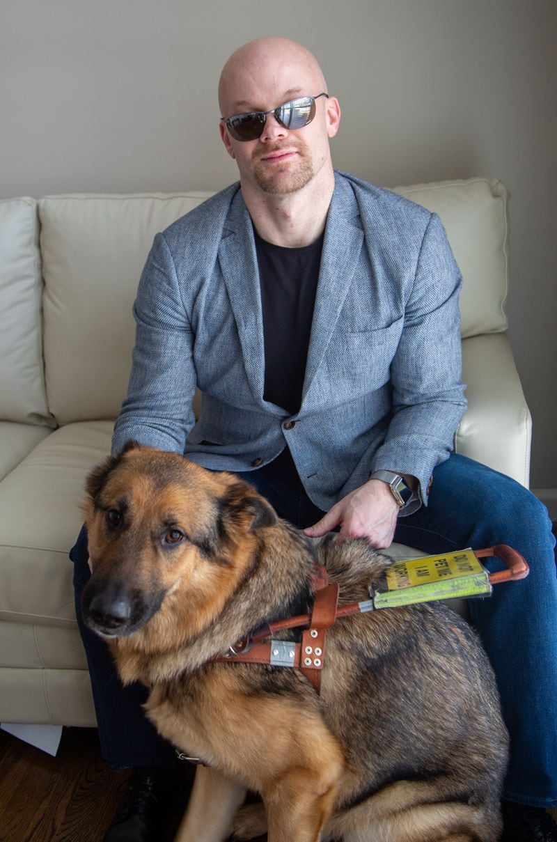 Portrait of Chad Foster with his service dog, Sarge, in his Marietta home. He is a blind man who is a successful business person, who skis downhill and who recently gave a motivational speech at his graduation from Harvard Business School’s leadership program. (Phil Skinner for The Atlanta Journal-Constitution)