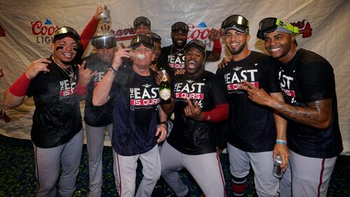 Atlanta Braves players celebrate in the club house after clinching their fifth consecutive NL East title by defeating the Miami Marlins 2-1, in a baseball game, Tuesday, Oct. 4, 2022, in Miami. (AP Photo/Wilfredo Lee)