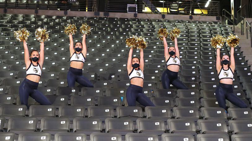 Georgia Tech cheerleaders mask up in mostly empty stands during the season opener against Georgia State in a NCAA college basketball game in Atlanta on Wednesday, Nov 25, 2020, in Atlanta. Georgia's public university system is encouraging, but not requiring staff and students to wear masks. (Curtis Compton / Curtis.Compton@ajc.com)