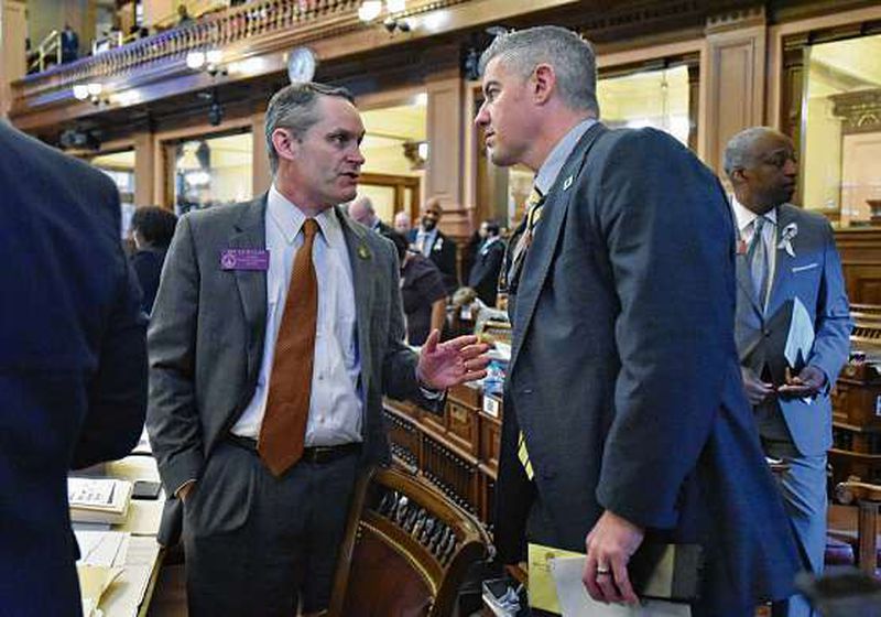 Rep. Ed Setzler (left), sponsor of the “heartbeat” anti-abortion bill likely to be signed into law by the governor, speaks with Rep. Kevin Cooke in the House chamber during the recent General Assembly. HYOSUB SHIN / HSHIN@AJC.COM