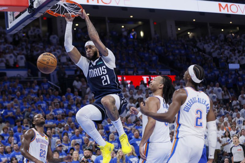 Dallas Mavericks center Daniel Gafford (21) dunks on Oklahoma City Thunder guard Shai Gilgeous-Alexander (2), forward Jaylin Williams (6) and guard Cason Wallace (22) during the first half of Game 1 of an NBA basketball second-round playoff series, Tuesday, May 7, 2024, in Oklahoma City. (AP Photo/Nate Billings)