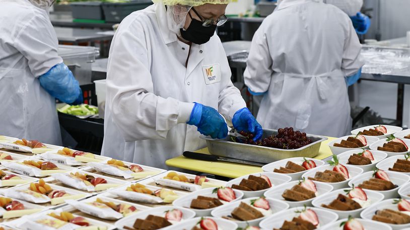Mainline Aviation employees plate meals for in-flight catering on Friday, August 5, 2022. (Natrice Miller/natrice.miller@ajc.com)