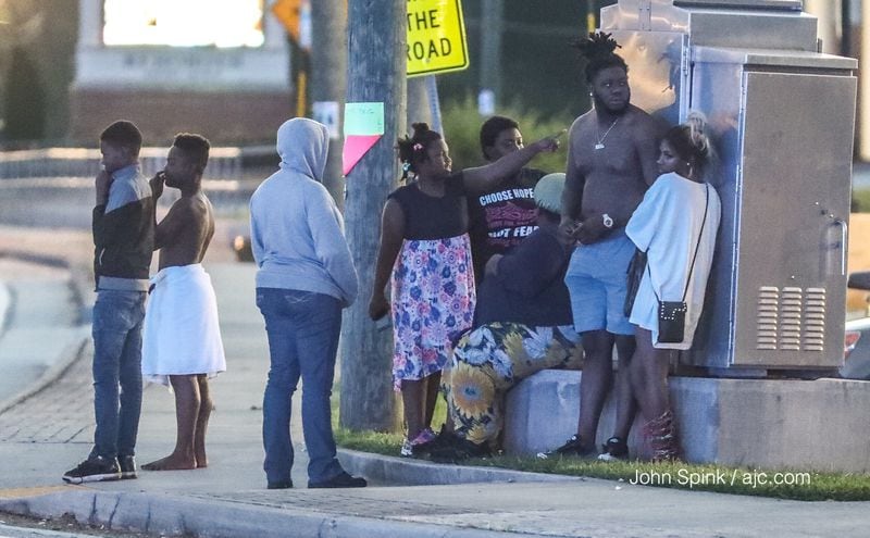 Evacuated motel guests waited for a SWAT standoff to end outside the Knights Inn on Lawrenceville Highway. JOHN SPINK / JSPINK@AJC.COM