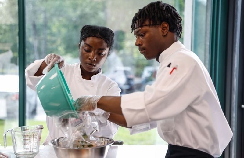 Navigate students Tanaya Brooks and Kevin Little prepare a marinade during a guided cooking lesson. (Natrice Miller/ AJC)