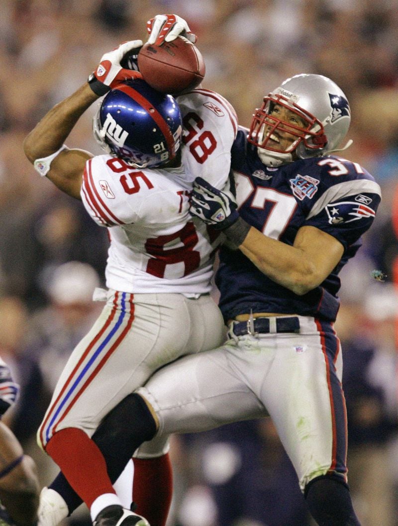 In this Feb. 3, 2008 file photo, New York Giants receiver David Tyree (85) catches a 32-yard pass in the clutches of New England Patriots safety Rodney Harrison (37) during the fourth quarter of the Super Bowl XLII football game at University of Phoenix Stadium in Glendale, Ariz. (AP Photo/Gene Puskar/FILE)