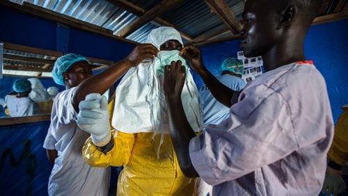 The following photo is in the David J. Sencer CDC Museum’s Ebola exhibit: A Liberian nurse prepares to draw blood from patients at the Ebola Treatment Unit. CONTRIBUTED BY MORGANA WINGARD, COURTESY OF USAID
