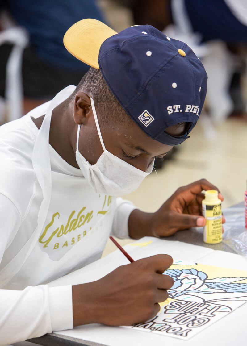 St. Pius X Catholic School football player Jack Tchienchou paints a heart board to show his support and appreciation to healthcare workers. PHIL SKINNER FOR THE ATLANTA JOURNAL-CONSTITUTION.