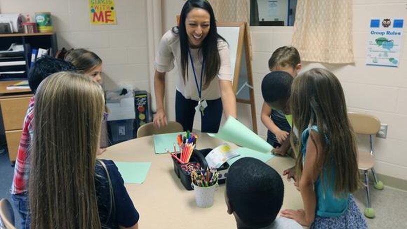 A school counselor works on social-emotional learning lessons with elementary school students