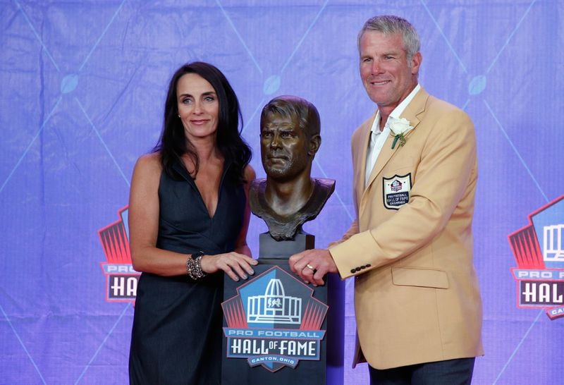 Brett Favre and his wife Deanna pose with his bronze bust during the NFL Hall of Fame enshrinement ceremony in Canton, Ohio, last year. He did not go in as a Falcon. (Joe Robbins, Getty Images)