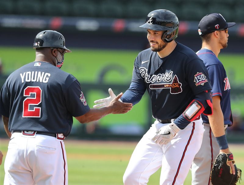 Atlanta Braves catcher Travis d’Arnaud gets five from first base coach Eric Young hitting a single against the Minnesota Twins Friday, March 5, 2021, at CoolToday Park in North Port, Fla. (Curtis Compton / Curtis.Compton@ajc.com)