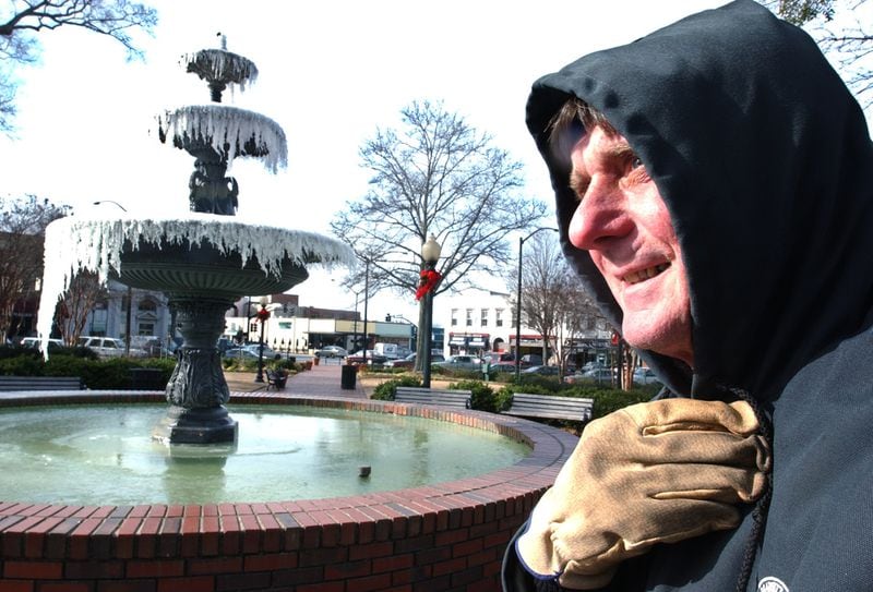 Jan. 7, 2004: City of Marietta employee Bob Keith tries to stay warm while cleaning Glover Park on the Marietta Square. The fountain sits frozen as the morning temperature in Marietta hovered around 19 degrees. (Andy Sharp/AJC)