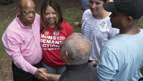 U.S. Rep. John Lewis stands with Lucy McBath, then a national spokeswoman for Moms Demand Action for Gun Sense in America, as they greet rally attendees at Woodruff Park in Atlanta in 2017. Tuesday, McBath won the Democratic nominatin in the 6th Congressional District. (DAVID BARNES / DAVID.BARNES@AJC.COM)