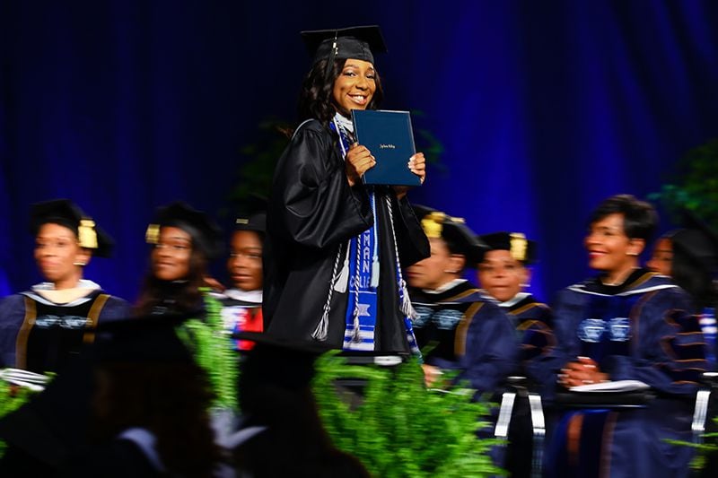 A graduate walks across the stage after receiving her degree at the 132nd Spelman College commencement ceremony on Sunday, May 19, 2019, at the Georgia International Convention Center. 