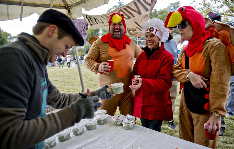Jessica Sherrill (right), Kimberly Odum and Sean Martin turn in their chili entry to Chris McCain during the 12th annual Cabbagetown Chomp & Stomp in Atlanta on Saturday, November 1, 2014. The one day festival attracts tens of thousands of people to taste chili, look at art, listen to music and celebrate the historic neighborhood. JONATHAN PHILLIPS / SPECIAL