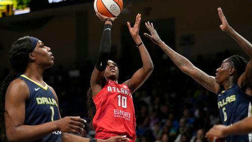 Dream guard Rhyne Howard (10) takes a shot as Dallas Wings' Teaira McCowan, left, and Natasha Howard (6) defend in the first half of Game 2 of a first-round WNBA basketball playoff series, Tuesday, Sept. 19, 2023, in Arlington, Texas. (AP Photo/Tony Gutierrez)