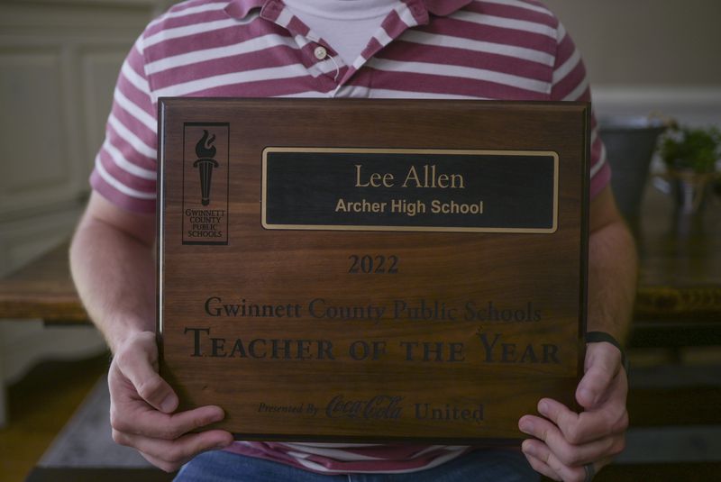 Lee Allen holds his teacher of the year plaque on Thursday, May 12, 2022. (Natrice Miller / natrice.miller@ajc.com)