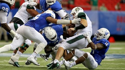 Charlotte 49ers quarterback Matt Johnson (8) is tackled by Georgia State Panthers defenders from left to right; defensive end Carnell Hopson (55), linebacker Joseph Peterson (6), and linebacker Alonzo McGee (4) in the third quarter of their game at the Georgia Dome, September 4, 2015, in Atlanta. Johnson fumbled the ball on the play. The 49ers won 23-20. PHOTO / JASON GETZ