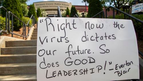 A quote by Gwinnett County School Board member Everton Blair is displayed on a demonstrator's sign during a rally and march created by the Gwinnett Educators for Equity and Justice outside of the Gwinnett County Public School Board building in Suwanee on July 20, 2020. Supporters of teachers and staff marched to demonstrate their concerns for starting off the school year in-person, instead of online, due to COVID-19. The Gwinnett County Public School Board announced that it will join most other districts in metro Atlanta and hold classes this fall online-only.  (ALYSSA POINTER / ALYSSA.POINTER@AJC.COM)