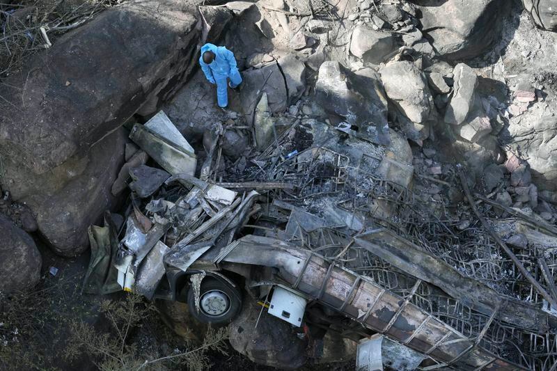 The wreckage off a bus lays in a ravine a day after it plunged off a bridge on the Mmamatlakala mountain pass between Mokopane and Marken, around 300km (190 miles) north of Johannesburg, South Africa, Friday, March 29, 2024. A bus carrying worshippers on a long-distance trip from Botswana to an Easter weekend church gathering in South Africa plunged off a bridge on a mountain pass Thursday and burst into flames as it hit the rocky ground below, killing at least 45 people, authorities said. The only survivor was an 8-year-old child who was receiving medical attention for serious injuries. (AP Photo/Themba Hadebe)